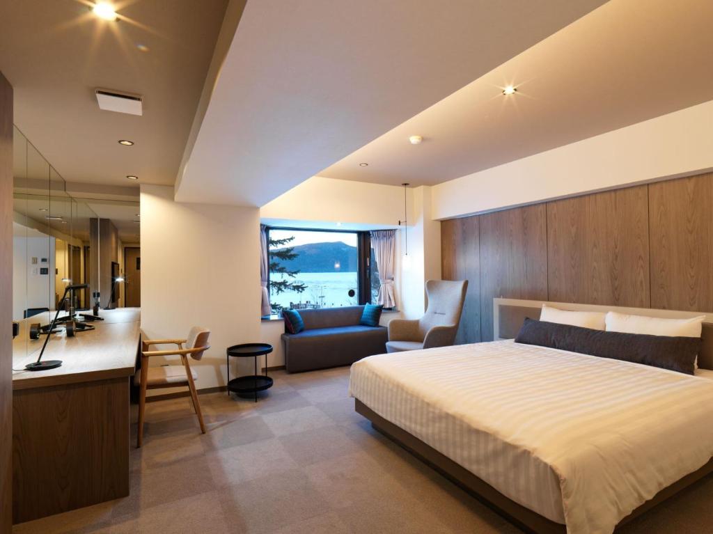 une chambre avec un lit et un bureau et une cuisine dans l'établissement THE FOREST AKAN Tsuruga Resort, à Akankohan