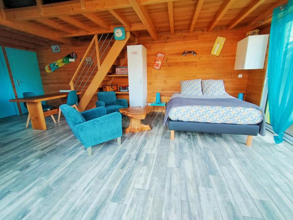 une chambre avec un lit, une table et des chaises dans l'établissement Gîte avec piscine et espace bien-être partagés entre Bordeaux et Lacanau océan, à Brach