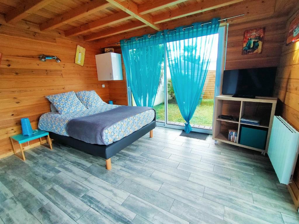 une chambre avec un lit et une grande fenêtre dans l'établissement Gîte avec piscine et espace bien-être partagés entre Bordeaux et Lacanau océan, à Brach