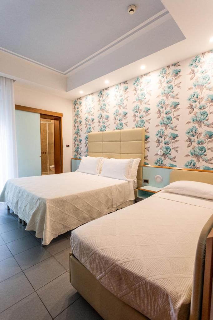 - 2 lits dans une chambre d'hôtel avec papier peint à fleurs dans l'établissement Hotel Gaby, à Rimini 83 autres photos