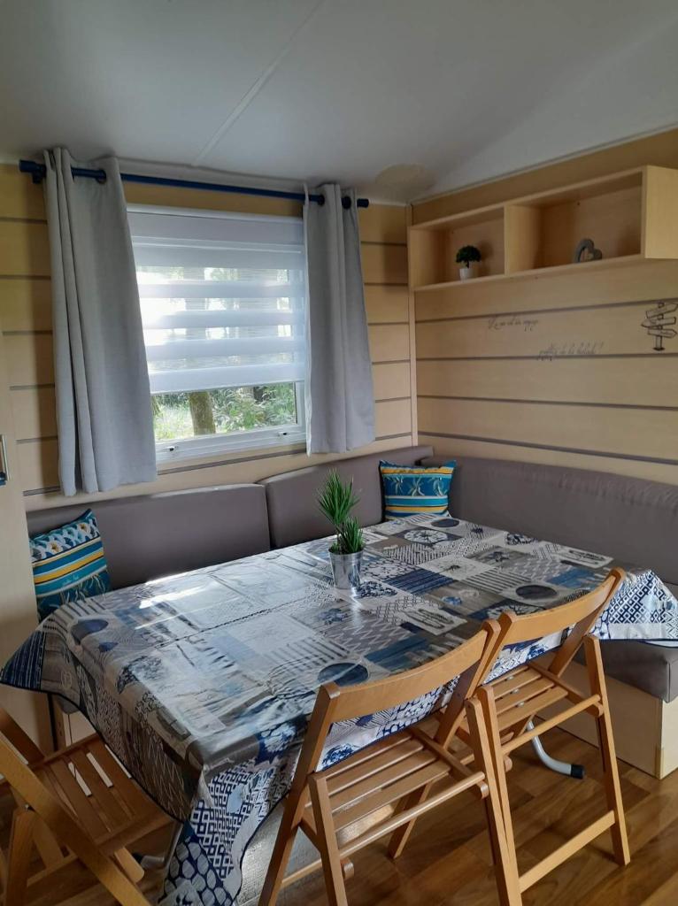 une salle à manger avec une table et des chaises et une fenêtre dans l'établissement F4 PREMIUM 6 pers PUY DU FOU 910CF, à La Boissière-de-Montaigu 5 autres photos