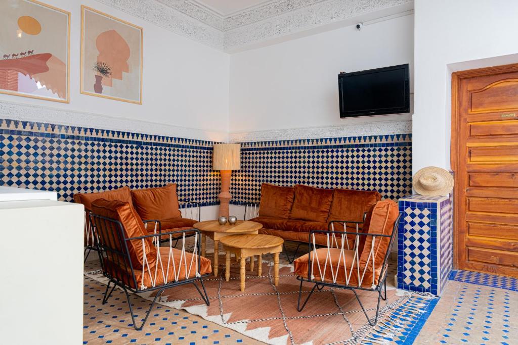 un salon avec un canapé, des chaises et une table dans l'établissement Riad Le Marocain, à Marrakech
