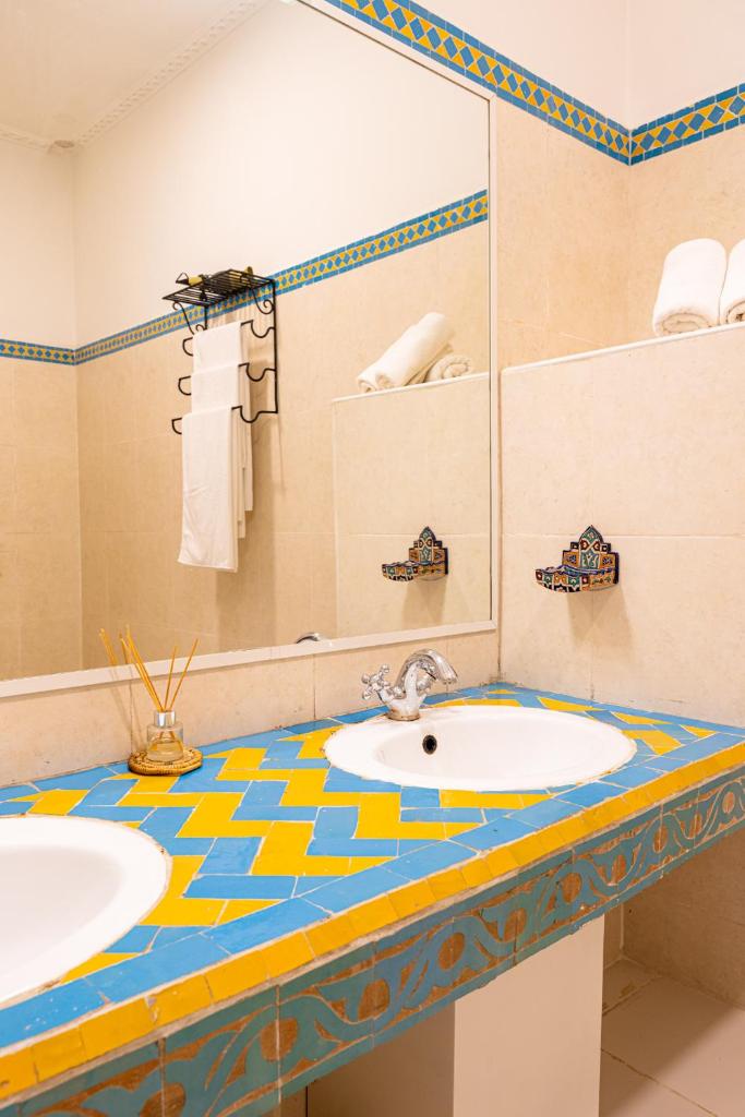 une salle de bain avec deux lavabos et un miroir dans l'établissement Riad Le Marocain, à Marrakech 32 autres photos