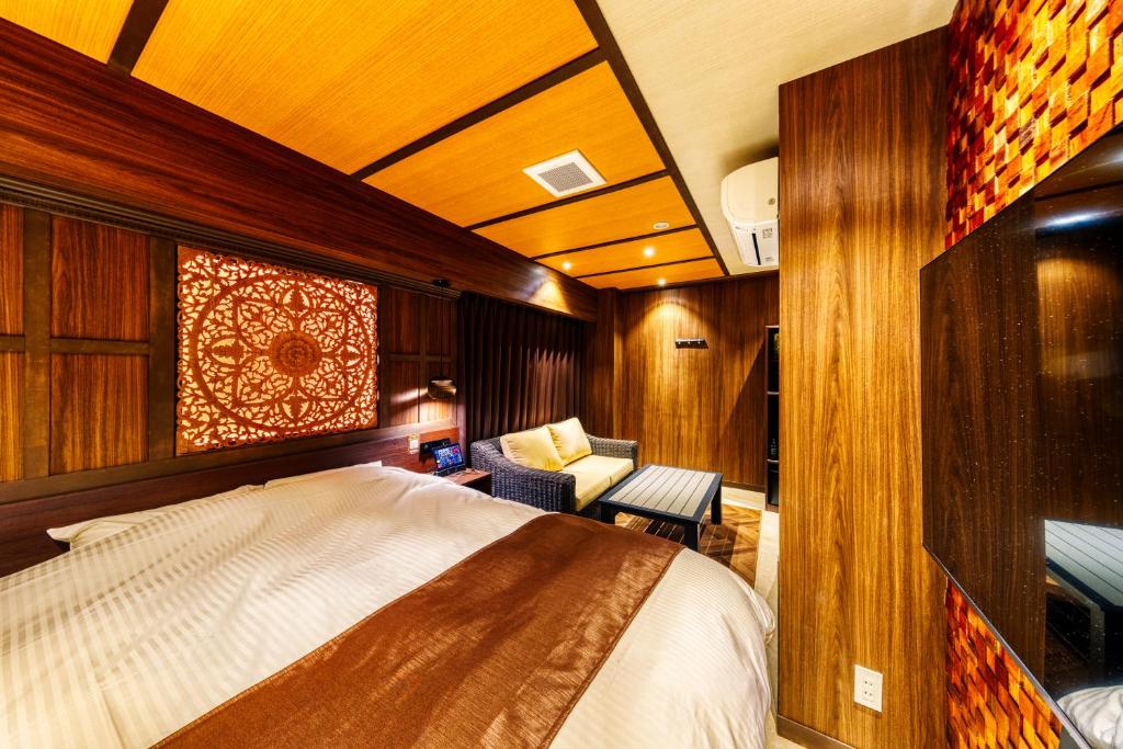 une chambre avec un lit et une chaise dans une pièce dans l'établissement Hotel Lotus Okayama Adult Only, à Okayama 4 autres photos