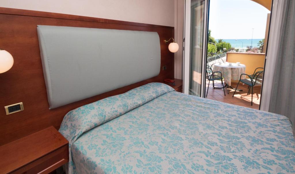 une chambre avec un lit et une vue sur un balcon dans l'établissement Hotel Costazzurra, à Grottammare