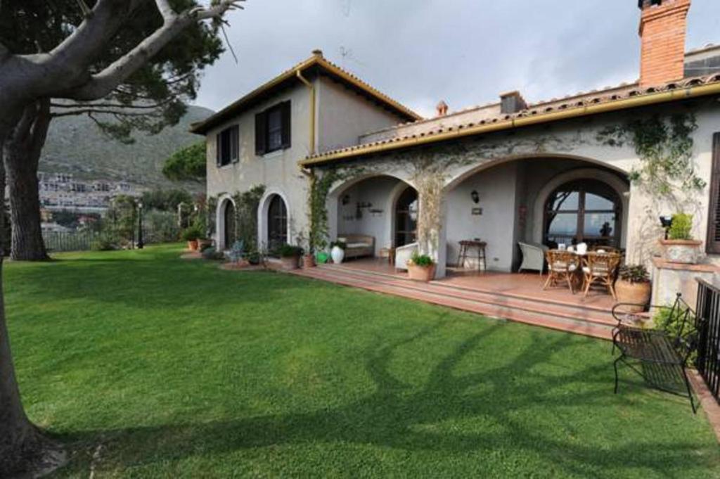 une maison avec une grande cour et une terrasse en bois dans l'établissement Il Casale, à Formia