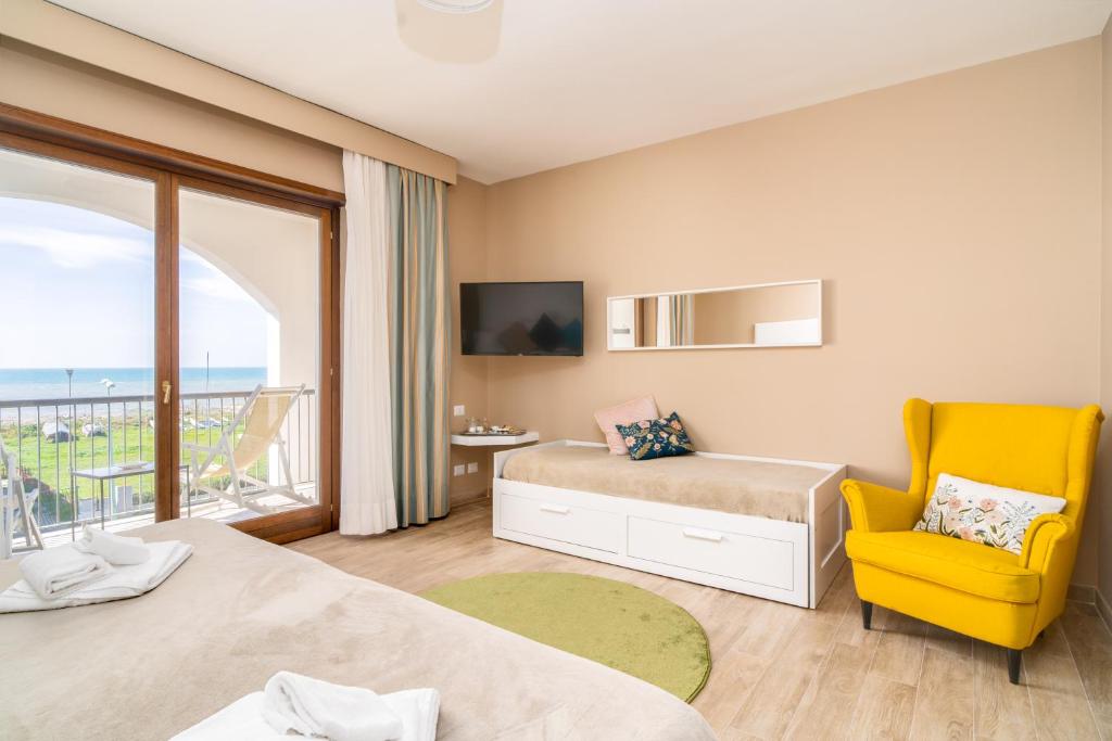 une chambre avec deux lits et une chaise jaune dans l'établissement Smy Civico Zero, à Tarquinia