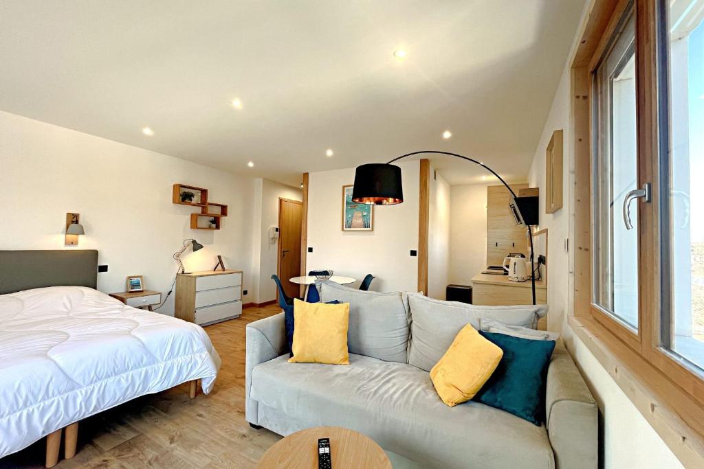 un salon avec un canapé et un lit ainsi qu'une chambre dans l'établissement L'Albigny - Lovely Studio - 150 m beach, à Annecy