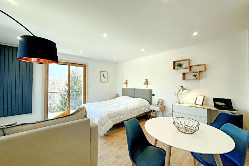 une chambre avec un lit, une table et des chaises dans l'établissement L'Albigny - Lovely Studio - 150 m beach, à Annecy