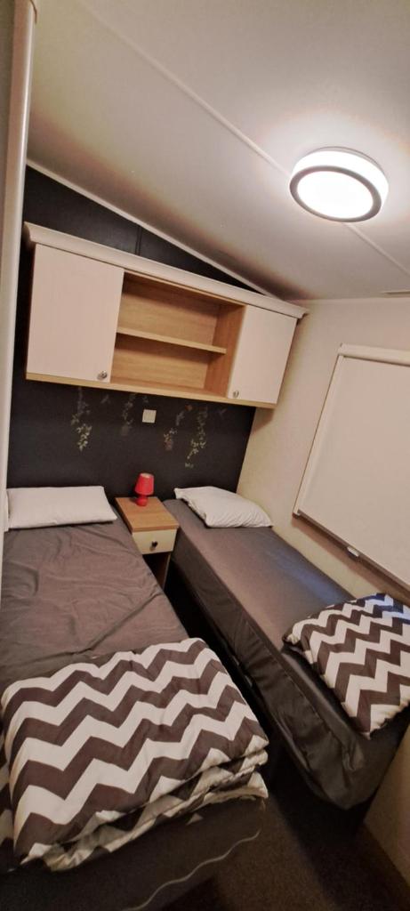 Cette petite chambre comprend 2 lits et un tableau blanc. dans l'établissement L'Exellence, à Fréjus