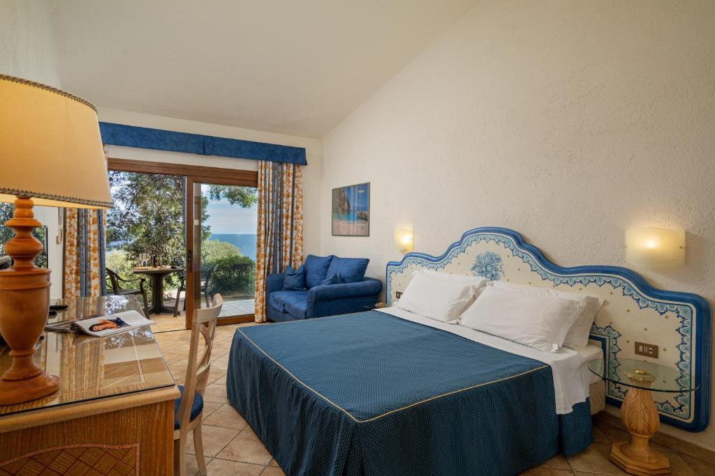 une chambre avec un lit bleu et une chaise bleue dans l'établissement Club Esse Palmasera, à Cala Gonone