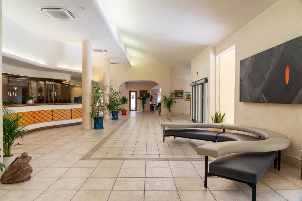 un hall avec des canapés et des plantes dans un bâtiment dans l'établissement Club Esse Palmasera, à Cala Gonone 90 autres photos