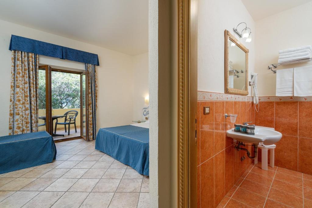 une chambre d'hôtel avec salle de bains et une chambre avec lavabo dans l'établissement Club Esse Palmasera, à Cala Gonone