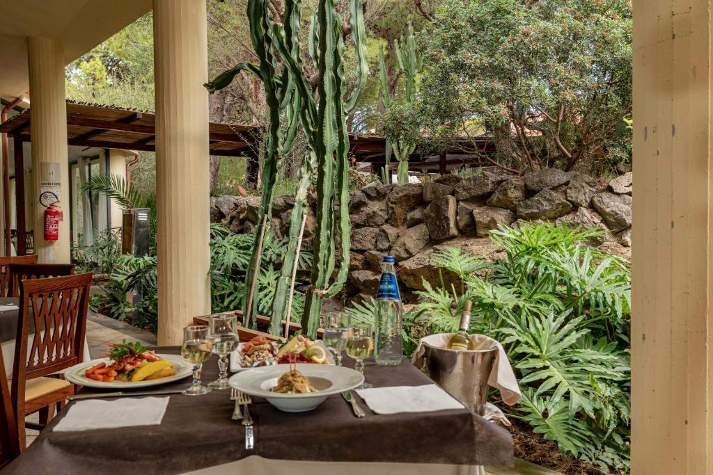 une table avec deux assiettes de nourriture dessus dans l'établissement Club Esse Palmasera, à Cala Gonone