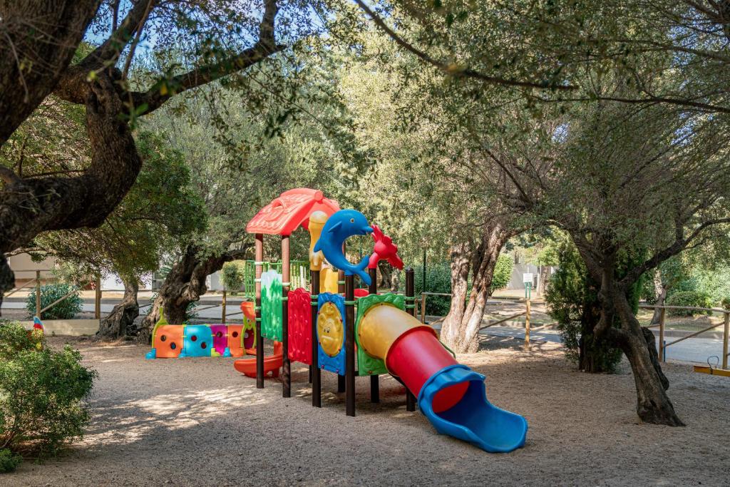 une aire de jeux avec un toboggan dans un parc arboré dans l'établissement Club Esse Palmasera, à Cala Gonone
