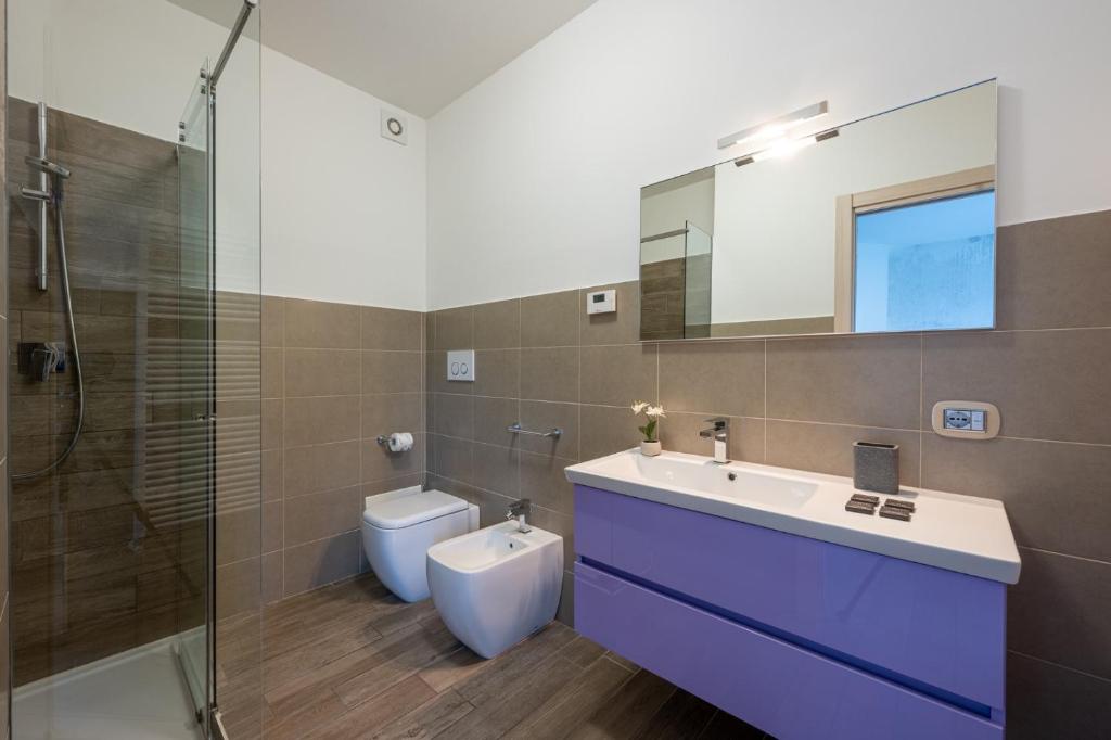 une salle de bain avec un lavabo, des toilettes et un miroir dans l'établissement Villa Costanza- private heated pool, steam room & sauna - Bellagio Village Residence, à Oliveto Lario