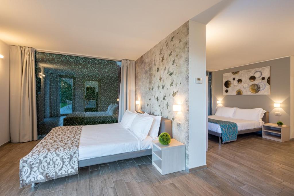 - une chambre avec un grand lit blanc et une chambre avec deux lits dans l'établissement Villa Costanza- private heated pool, steam room & sauna - Bellagio Village Residence, à Oliveto Lario