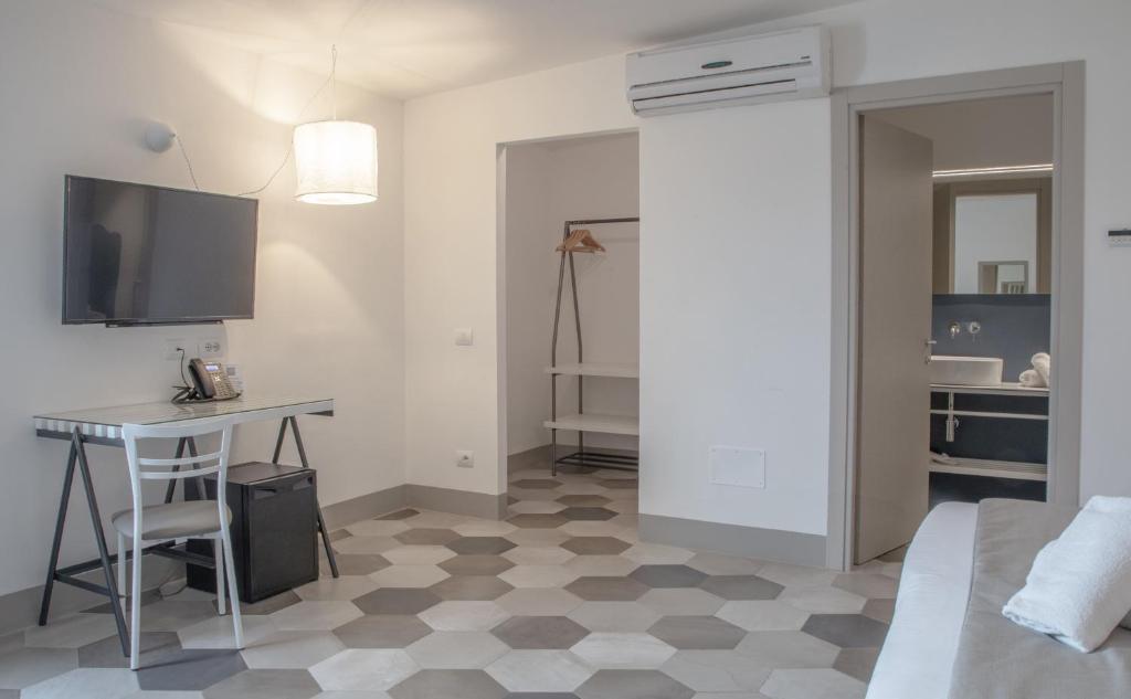 une chambre avec un lit, un bureau et une table dans l'établissement Hotel Villa Ambra, à Orbetello