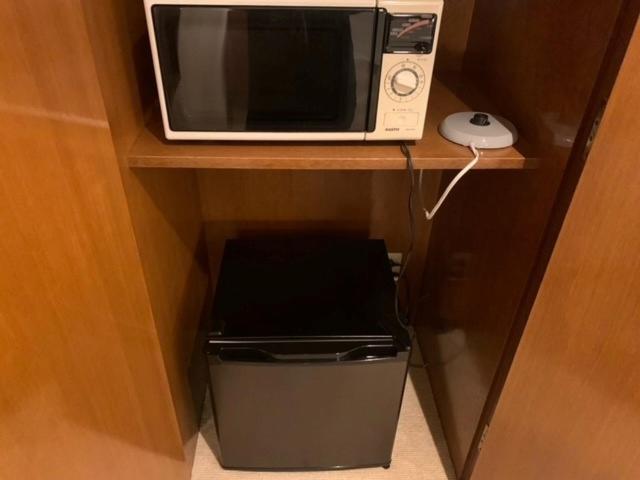 un four micro-ondes assis sur une étagère avec une poubelle dans l'établissement Hotel HANAMIZUKI-Adult Only, à Otaru 8 autres photos