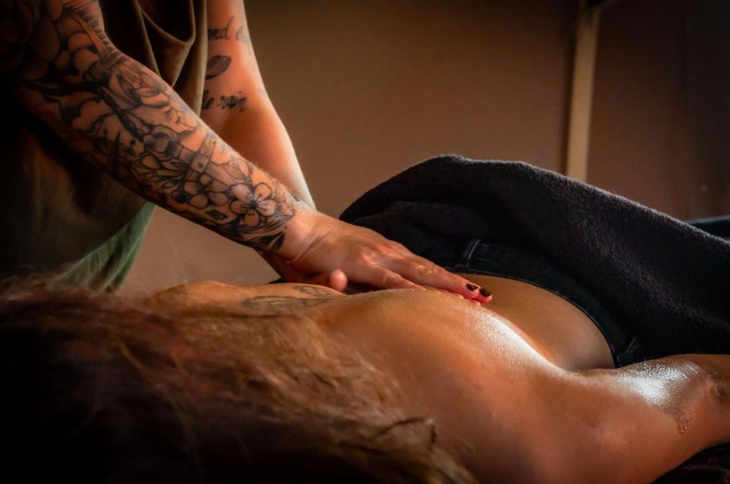 une femme tatouée sur une jambe de homme dans l'établissement La Réserve Bagherra nuit insolite et soins bien-être, à Saint-Girons-dʼAiguevives