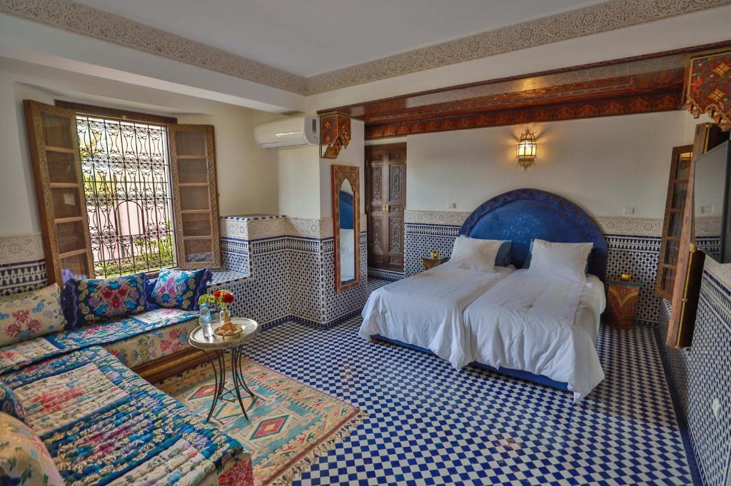 une chambre avec un grand lit et un canapé dans l'établissement Riad Semlalia, à Fès