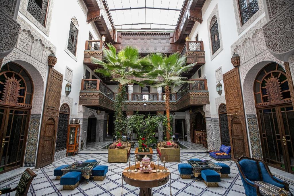 une cour intérieure dans un bâtiment avec des palmiers dans l'établissement Riad Semlalia, à Fès