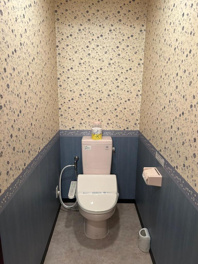 - une salle de bains avec toilettes dans une chambre aux murs bleus dans l'établissement ホテルSpace24, à Miyakonojō