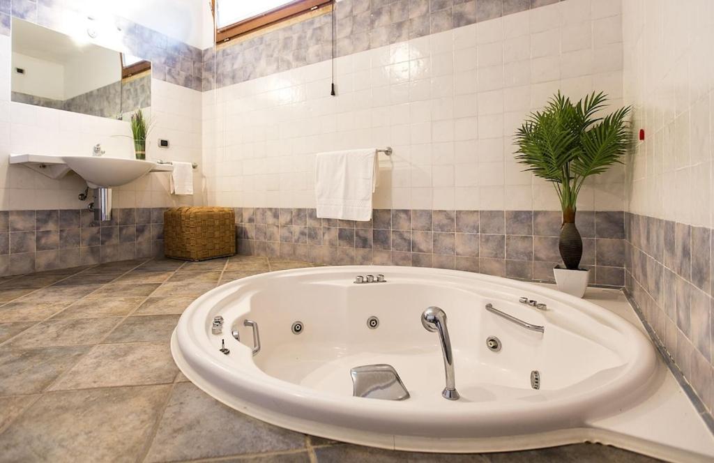 une salle de bain avec une grande baignoire et un lavabo dans l'établissement ClickSardegna Villa Paraiba fronte mare per 12 persone, à Alghero