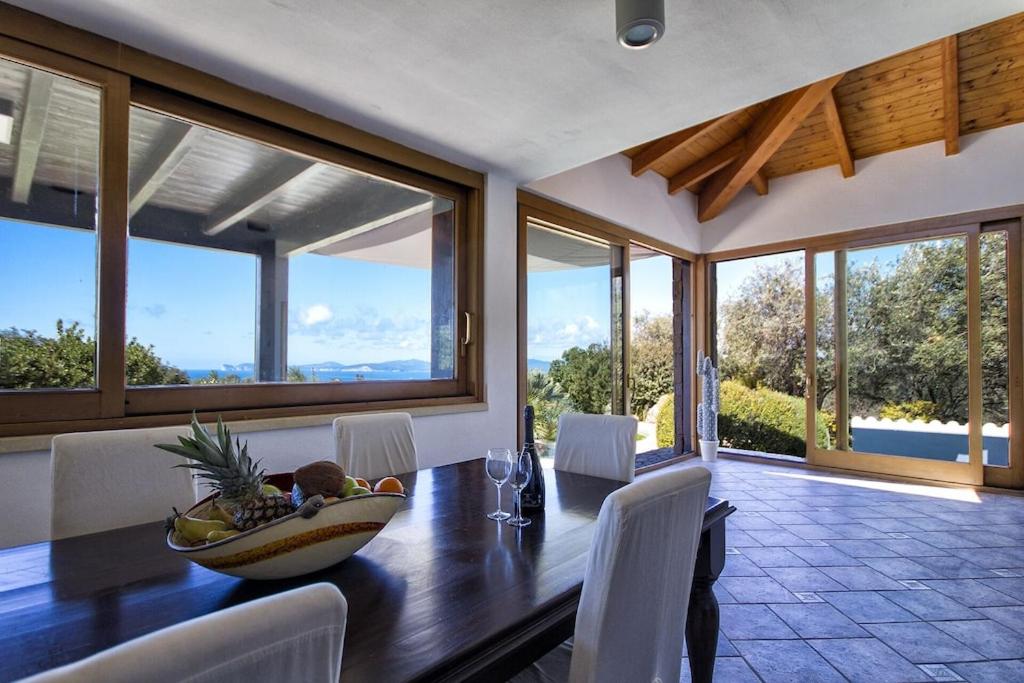 une salle à manger avec une table avec un bol de fruits dessus dans l'établissement ClickSardegna Villa Paraiba fronte mare per 12 persone, à Alghero