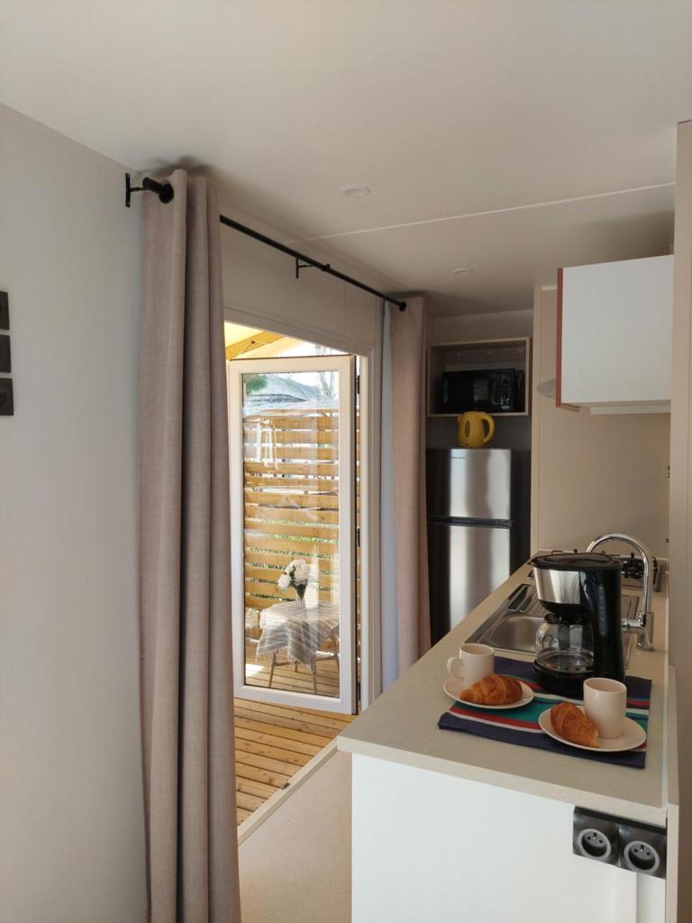 une cuisine avec un comptoir et une fenêtre dans l'établissement Spacieux mobilhome climatisé 4 P au GRAU du Roi en Camargue, au Grau-du-Roi