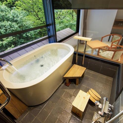 une grande baignoire dans une pièce avec une fenêtre dans l'établissement Hotel Okuyumoto, à Hakone