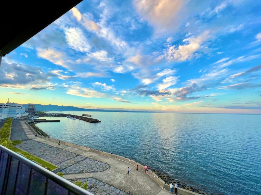 une vue sur une étendue d'eau avec un ciel nuageux dans l'établissement SKY Bali Style Beppu, Resort Love Hotel, à Beppu