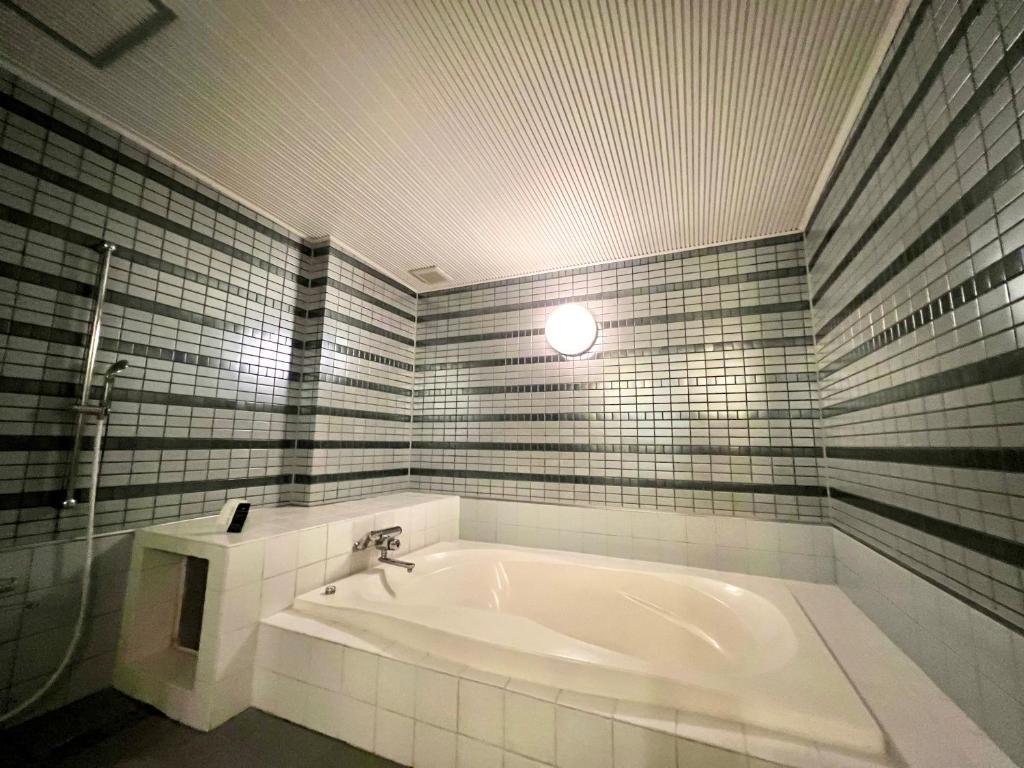 La salle de bains est pourvue d'une baignoire et d'un lavabo. dans l'établissement SKY Bali Style Beppu, Resort Love Hotel, à Beppu