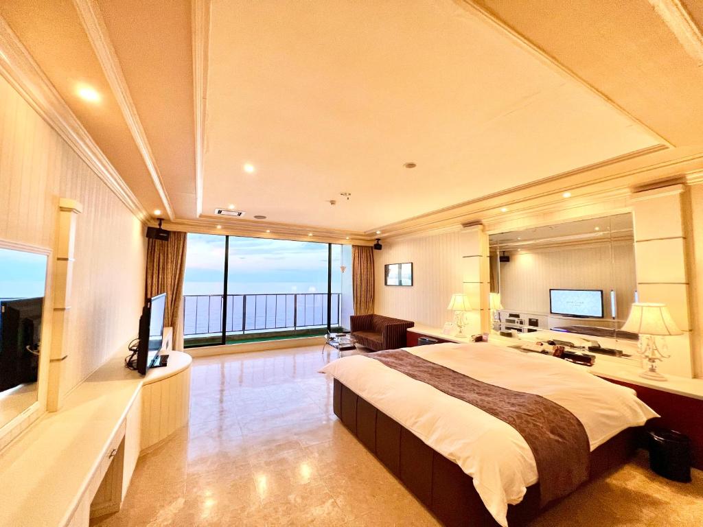 une grande chambre avec un grand lit et un balcon dans l'établissement SKY Bali Style Beppu, Resort Love Hotel, à Beppu
