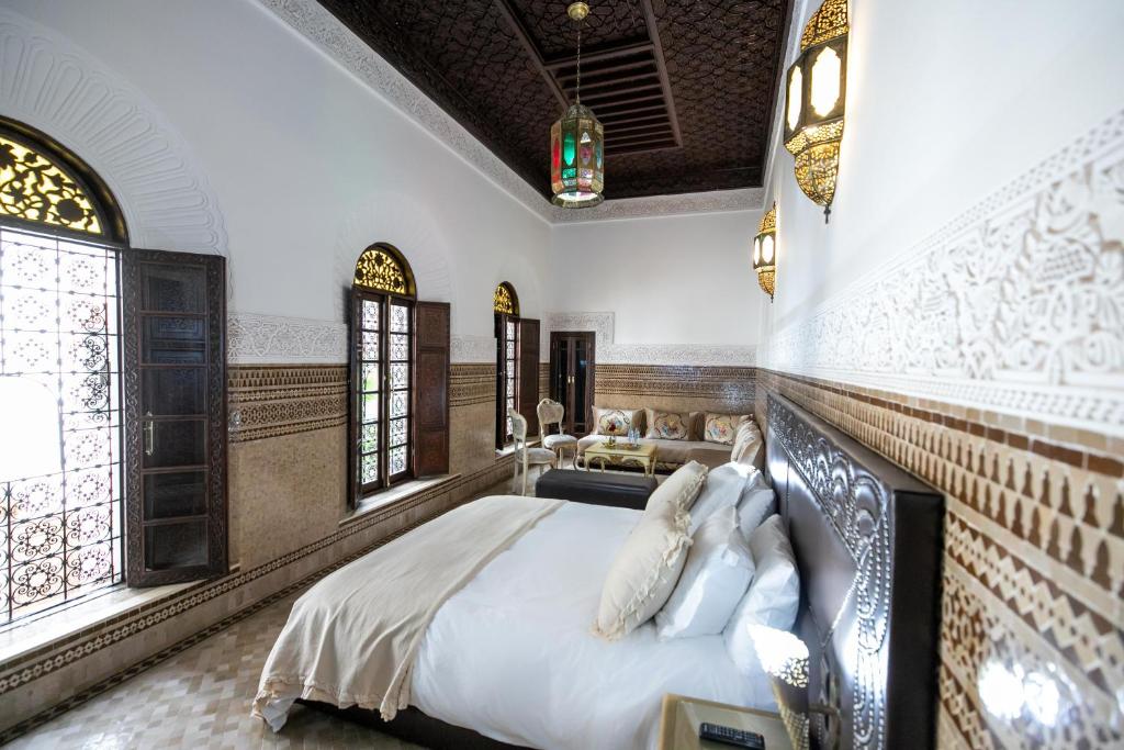une chambre avec un lit dans une pièce avec des fenêtres dans l'établissement Riad Semlalia, à Fès