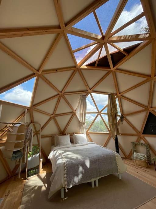 - une chambre avec un lit dans une grande tente dans l'établissement Dôme insolite Lichen jacuzzi et petits-déjeuners inclus, à Gondrin
