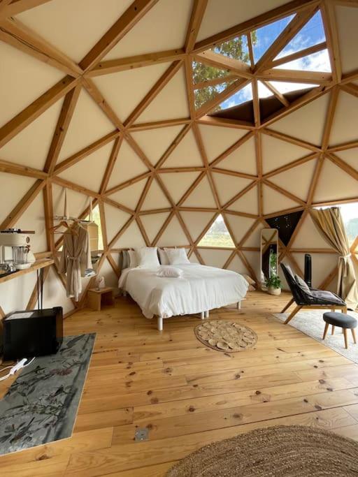une grande chambre avec un lit dans une tente dans l'établissement Dôme insolite Cèdre jacuzzi et petits déjeuners inclus, à Lagraulet-du-Gers