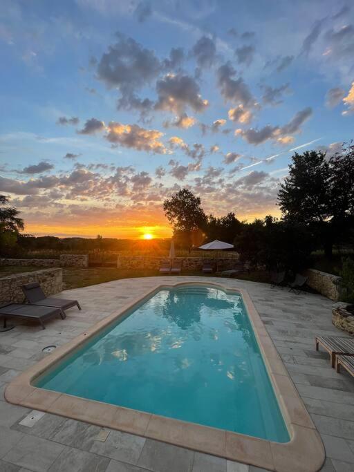 une grande piscine avec un coucher de soleil en arrière-plan dans l'établissement Dôme insolite Cèdre jacuzzi et petits déjeuners inclus, à Lagraulet-du-Gers