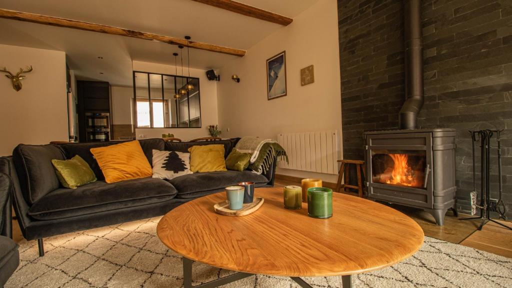 - un salon avec un canapé et un poêle à bois dans l'établissement Chalet Peak Noir entier 12pers - Cosy House Peak Noir for 12people, au Monêtier-les-Bains