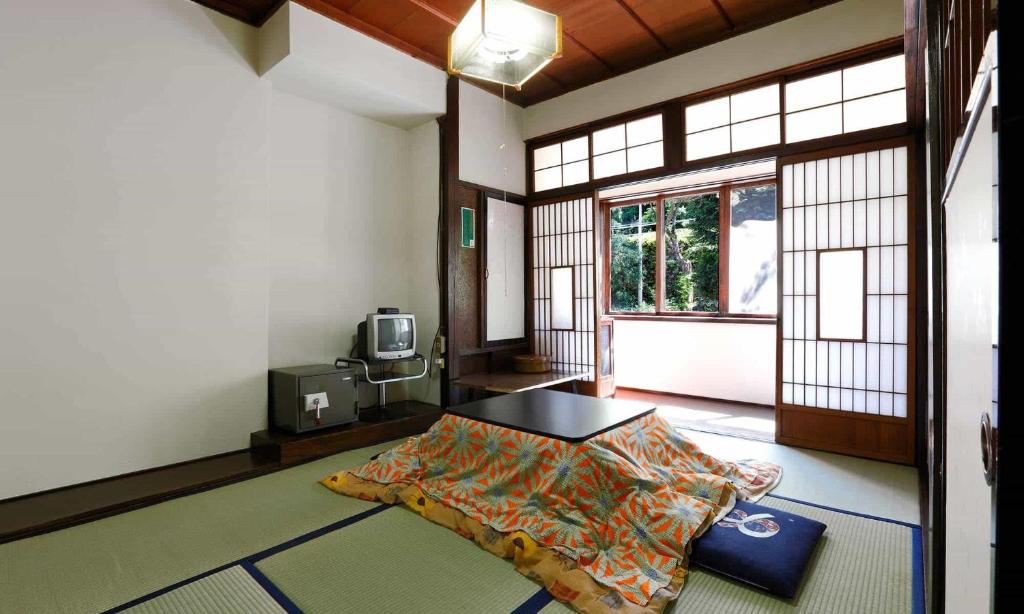 une chambre avec un lit au milieu d'une pièce dans l'établissement Fujisan Ryokan, à Hanamaki
