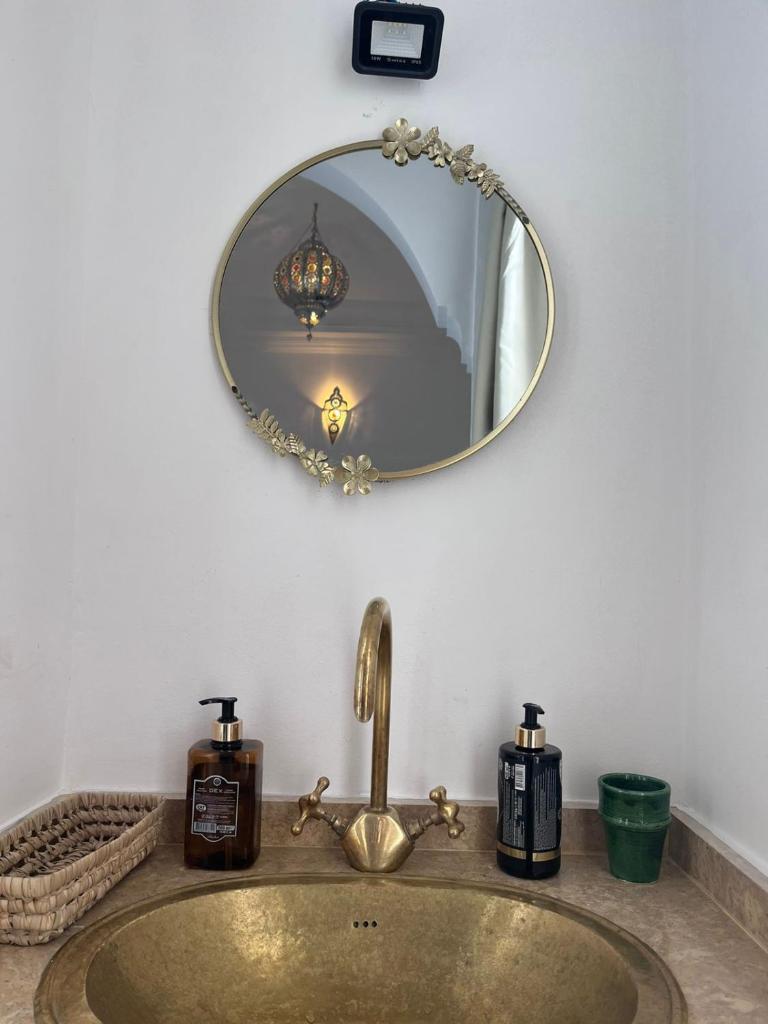 La salle de bains est pourvue d'un lavabo et d'un miroir mural. dans l'établissement Riad Black Doors, à Marrakech
