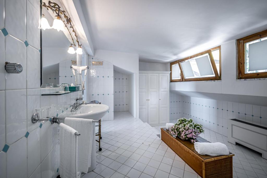 une salle de bain blanche avec un lavabo et un miroir dans l'établissement Palazzo Belmonte, à Santa Maria di Castellabate