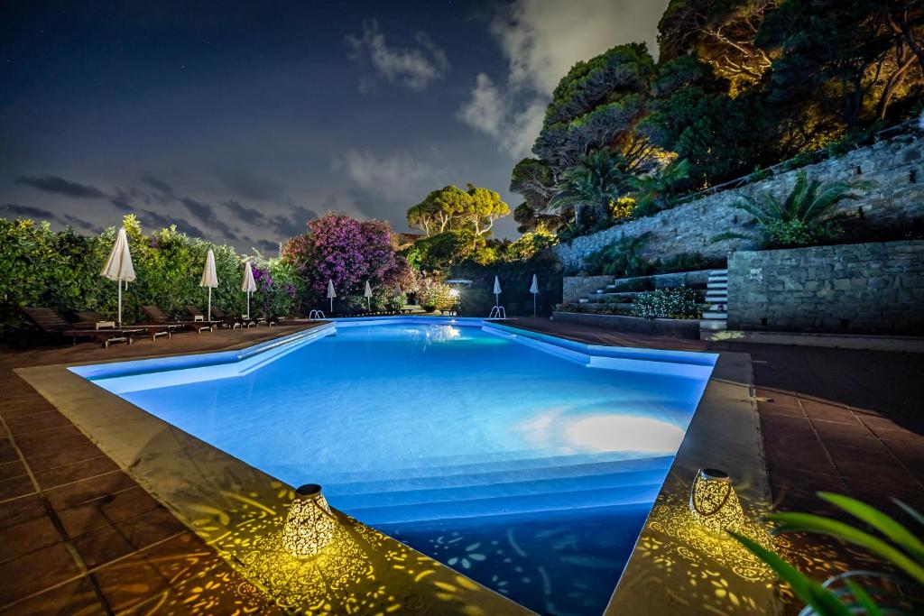 une grande piscine bleue la nuit dans l'établissement Palazzo Belmonte, à Santa Maria di Castellabate