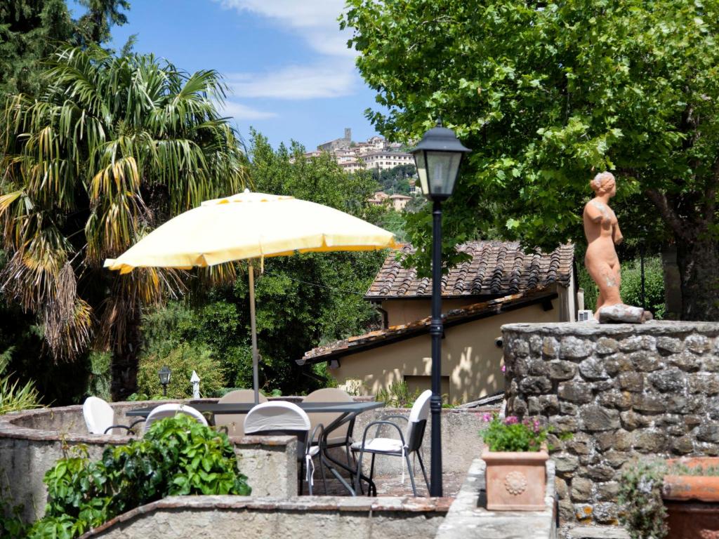 une statue d'un homme sur un mur avec un parapluie dans l'établissement Villa Arcitenens by Interhome, à Cortone