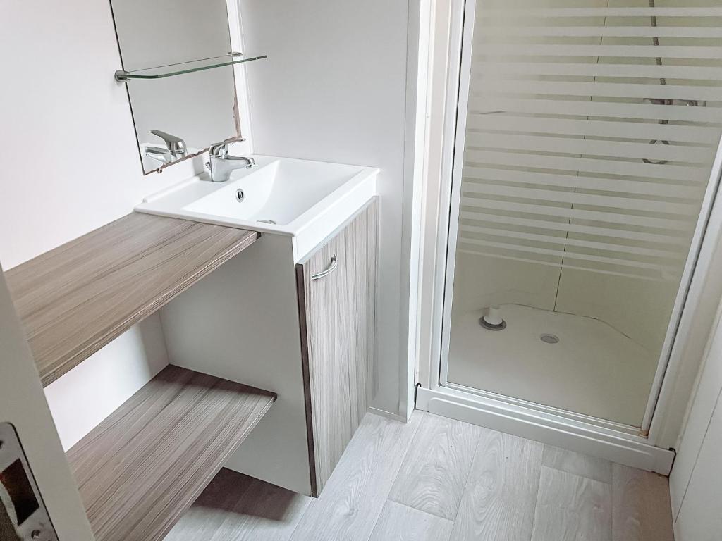 une salle de bain blanche avec un lavabo et une douche dans l'établissement 3 bedroom Chalets Camping Leï Suves - JoyCasa, à Roquebrune-sur Argens 37 autres photos