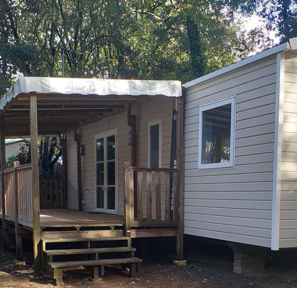 une petite cabine avec une terrasse couverte et une terrasse dans l'établissement Mobilhome Bora Bora 2018 Camping Les Pierres Couchées Saint Brevins les Pins, à Saint-Brévin-les-Pins