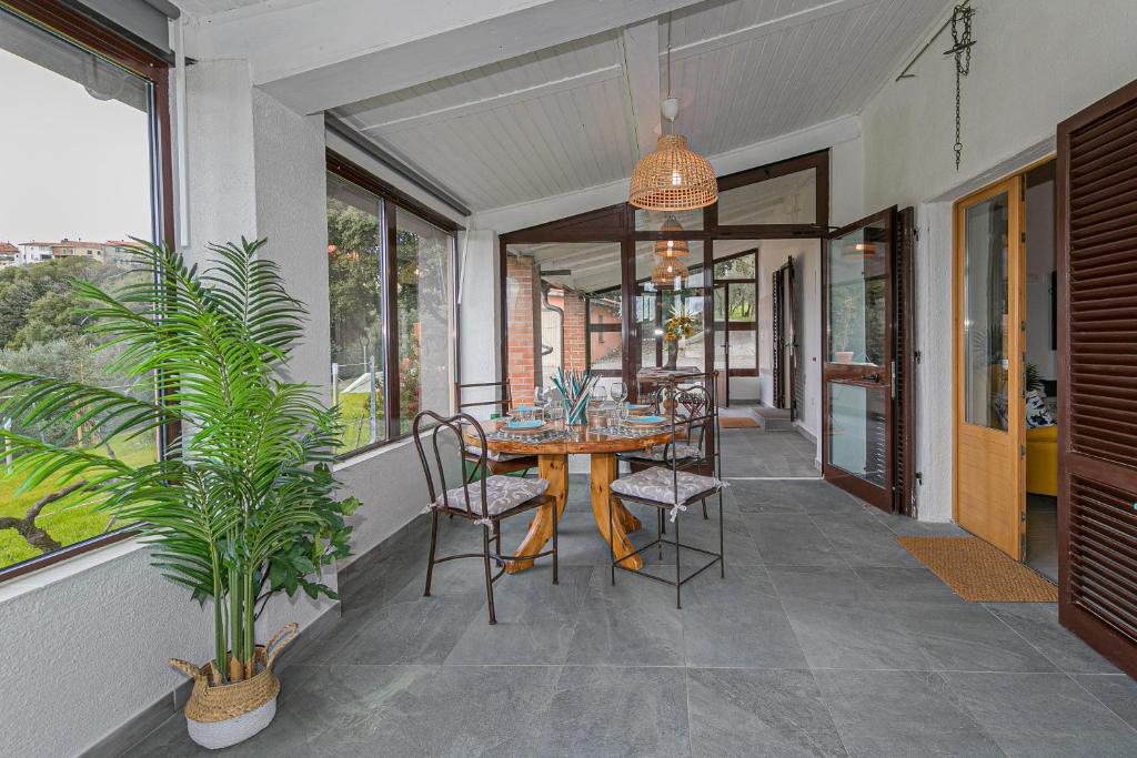 une salle à manger avec une table et des chaises sur un porche dans l'établissement Villa Cristina, à Riparbella