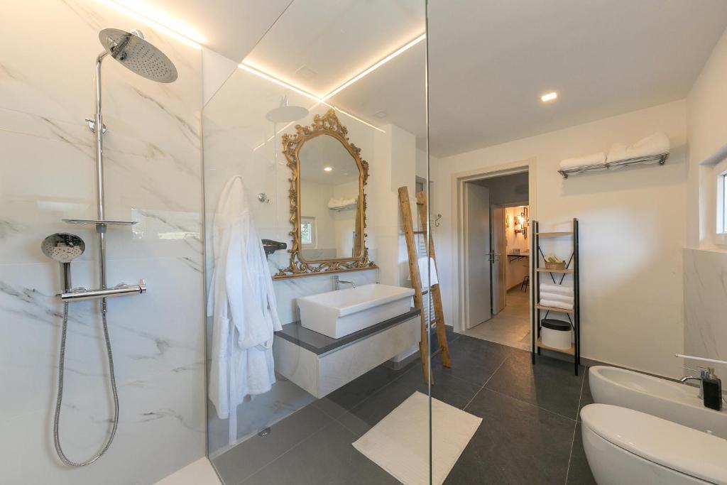 une salle de bain avec douche, lavabo et toilettes dans l'établissement Villa Cristina, à Riparbella