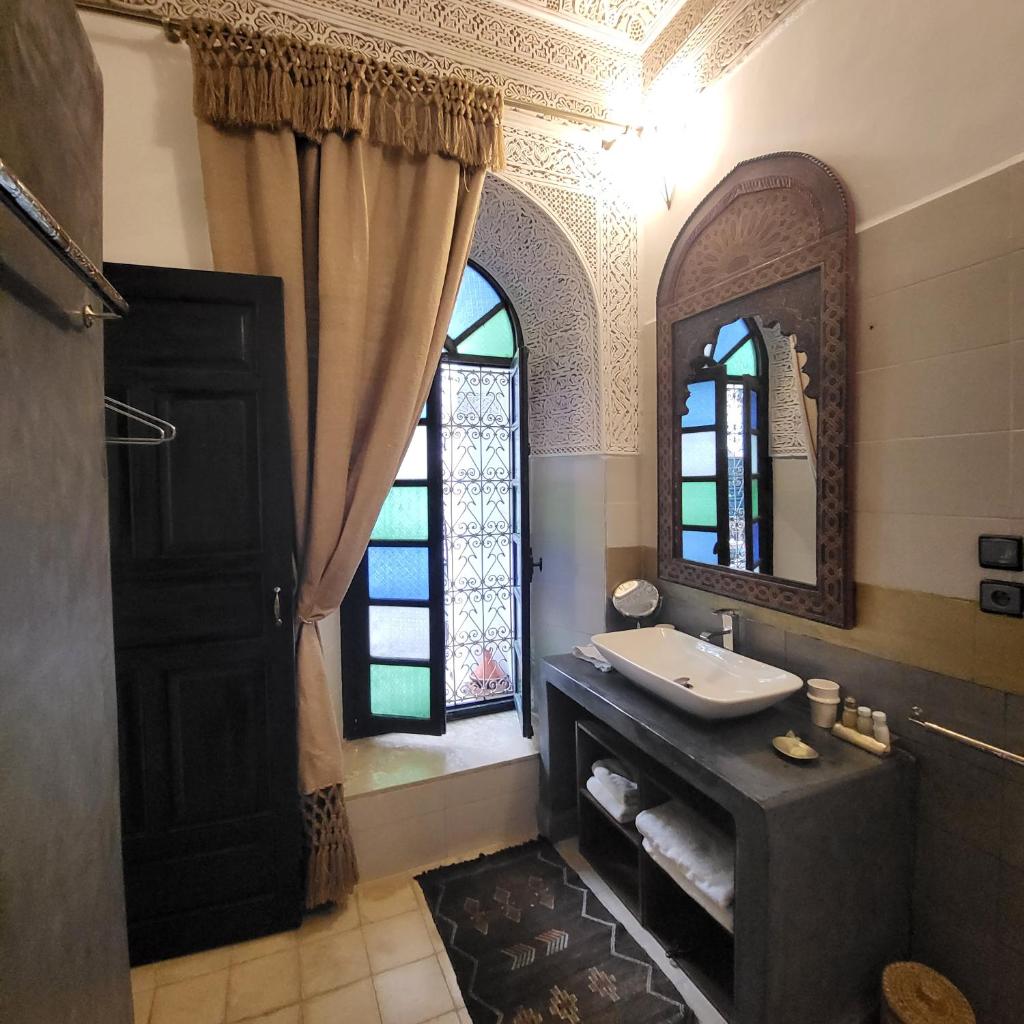 une salle de bain avec un lavabo, un miroir et une fenêtre dans l'établissement Riad Aloes & Spa, à Marrakech