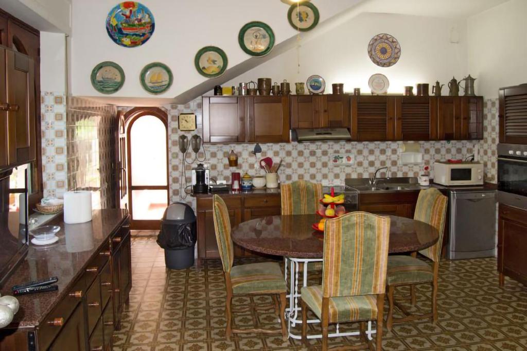 une cuisine avec une table et des chaises dans une pièce dans l'établissement Villa alkantara, à Taormine
